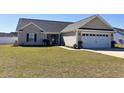 Inviting single-story home featuring a well-manicured lawn and an attached two-car garage at 429 Oakham Dr., Conway, SC 29526