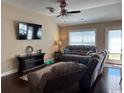 Cozy living area with a TV, wood flooring, a ceiling fan, and access to the backyard at 429 Oakham Dr., Conway, SC 29526