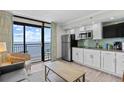Cozy kitchen features modern appliances, bright white cabinets, and a scenic view of the ocean from the sliding glass door at 4800 S Ocean Blvd. # 1524, North Myrtle Beach, SC 29582