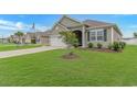 Inviting single-Gathering home with a lush green lawn and a young tree, showcasing curb appeal at 5018 Oat Fields Drive, Myrtle Beach, SC 29588