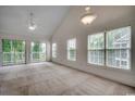 Spacious living room with large windows, sliding glass doors, vaulted ceilings and ceiling fan at 5046 Belleglen Court # 202, Myrtle Beach, SC 29579