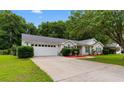 Exterior view of a home featuring an attached garage, mature trees and manicured landscaping at 556 Crusade Circle, Conway, SC 29526
