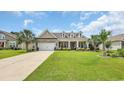 Lovely home with a well-kept lawn, complemented by mature palm trees at 698 Lafayette Park Dr., Little River, SC 29566