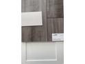 A sample of the luxury vinyl plank flooring and white cabinets to be installed at 982 Oak Hollow St., Longs, SC 29568