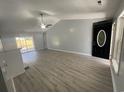 Bright living room with vaulted ceiling, laminate flooring, and sliding doors to the outdoor space at 9888 Conifer Ln., Murrells Inlet, SC 29576