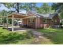 Property with a covered carport or storage area, complemented by a well-kept lawn and partial fencing at 1217 S Highway 501, Marion, SC 29571