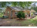 Brick home showcasing a side porch, manicured shrubbery and convenient access to the backyard and air conditioning unit at 1217 S Highway 501, Marion, SC 29571
