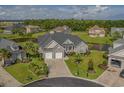 Beautiful aerial view of a landscaped home with water view and manicured lawn at 1323 Ashboro Ct., Myrtle Beach, SC 29579