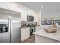 Modern kitchen with stainless steel appliances, granite countertops, and stylish white cabinetry at 1429 Nokota Dr., Conway, SC 29526