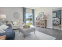 Bright living room with large windows offering lake views, elegant furnishings, and hardwood floors at 1429 Nokota Dr., Conway, SC 29526