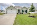 Inviting one-story home with lush green lawn, front yard landscaping, and attached garage at 211 Seasons Trace Loop, Longs, SC 29568