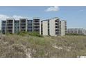 Exterior shot of the condo buildings showcasing multiple balconies and views at 417 S Dunes Dr., Pawleys Island, SC 29585