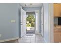 Bright foyer with tiled floor, blue walls, and the front door open showcasing the front yard at 4197 Friendfield Trace, Little River, SC 29566