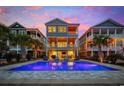 Backyard of coastal home featuring a private pool, multiple balconies and outdoor seating at 496 West Palm Dr., Myrtle Beach, SC 29579