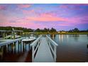 Private dock with boat lift overlooking calm water during a colorful sunset at 496 West Palm Dr., Myrtle Beach, SC 29579