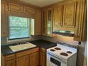 Cozy kitchen with wood cabinets, black countertops, and stainless-steel range hood at 911 Park Ave., Marion, SC 29571