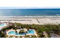 Oceanfront resort with a vibrant pool area, palm trees and beach access at 9994 Beach Club Dr. # 1202, Myrtle Beach, SC 29572