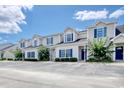 View of the townhomes showcasing the beige siding, blue shutters, and ample parking space at 105 Spring Creek Dr. # C, Myrtle Beach, SC 29588