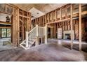 Unfinished living room featuring exposed wooden beams, staircase, and a fireplace at 1311 9Th Ave., Conway, SC 29526