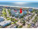 Aerial view of a beautiful coastal home with colorful houses, beach access, and pristine ocean views at 1473 Basin Trail, Murrells Inlet, SC 29576