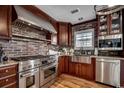 Gourmet kitchen with stainless steel appliances, brick backsplash, custom cabinets, and a chef-grade range at 1473 Basin Trail, Murrells Inlet, SC 29576
