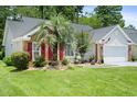 Beautifully landscaped home with a well-manicured lawn, gray siding, red shutters and a two car garage at 183 Glenwood Dr., Conway, SC 29526