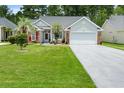 Charming home with a well-manicured lawn, gray siding, brick accents, and a two car garage at 183 Glenwood Dr., Conway, SC 29526