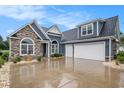 Beautiful blue home featuring a two-car garage, stone accents, and manicured landscaping at 1844 Wood Stork Dr., Conway, SC 29526