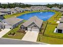 Aerial view of a home in a serene neighborhood with a scenic pond, lush greenery, and well-maintained landscaping at 215 Kendrick St., Little River, SC 29566