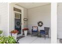 Inviting front porch with decorative chairs, wreaths, and potted flowers creating a cozy entrance at 215 Vivian St. Nw # 215, Calabash, NC 28467