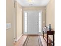 Inviting foyer with wood-look tile flooring, side-light windows, and a decorative table with a lighthouse sculpture at 4554 Fringetree Dr., Murrells Inlet, SC 29576