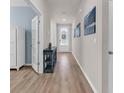 Inviting hallway with beautiful wood floors, neutral paint and decor, leading to the front door at 520 Cattle Drive Circle, Myrtle Beach, SC 29588