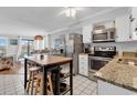 Bright kitchen featuring white cabinets, stainless steel appliances, an island, and breakfast area at 5601 N Ocean Blvd. # B316, Myrtle Beach, SC 29577