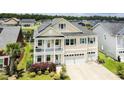 Charming home with a two-car garage, light siding, blue shutters, solar panels, and a second-story balcony at 6186 Chadderton Circle, Myrtle Beach, SC 29579