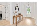 Bright entryway featuring hardwood floors, a wooden console table, and a front door allowing ample natural light at 6304 Chadderton Circle, Myrtle Beach, SC 29579