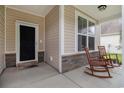 Cozy front porch featuring stone accents, rocking chairs, and a welcoming entrance at 632 Lafayette Park Dr., Little River, SC 29566