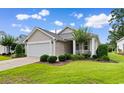 A charming single story home with lovely front yard landscaping on a sunny day at 637 Grand Cypress Way, Murrells Inlet, SC 29576