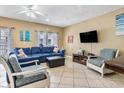 Inviting living room with comfortable blue couch, tile floors, and ceiling fan at 704 S Ocean Blvd. # 304A, Myrtle Beach, SC 29577