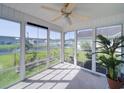 Bright sunroom with large windows offering views of the backyard, complemented by a ceiling fan at 708 Shenanigan Loop, Murrells Inlet, SC 29576