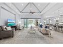 Cozy living room with vaulted ceilings, a ceiling fan, and sliding glass doors leading to the pool area at 7961 San Marcello Dr., Myrtle Beach, SC 29579