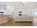 Open-concept living space featuring vaulted ceilings, fireplace, modern seating, and breakfast bar at 865 Summer Starling Pl., Myrtle Beach, SC 29577