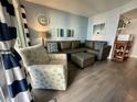 Inviting living room boasts a comfortable sectional, patterned accent chair, and sliding door for natural light at 920 N Waccamaw Dr. # 2206, Garden City Beach, SC 29576