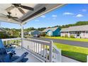 Inviting covered porch with comfortable seating and a view of the quiet neighborhood street at 9466 Old Palmetto Dr., Murrells Inlet, SC 29576