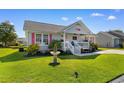 Beautiful single-story home with a manicured lawn, a decorative fountain, and bright pink accents at 9466 Old Palmetto Dr., Murrells Inlet, SC 29576