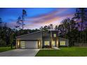 Beautiful home with a modern design and stone accents, complemented by a vibrant sunset and manicured lawn at 1028 Colette Ct, Conway, SC 29526