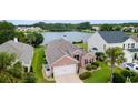 Beautiful brick home with lush landscaping, an attached garage, and a tranquil lake view at 2210 Haystack Way, Myrtle Beach, SC 29579