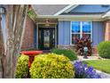 Inviting front entrance with a decorative door, lovely landscaping, and colorful flowering plants at 2369 Clandon Dr., Myrtle Beach, SC 29579