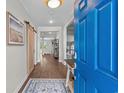 Bright foyer featuring wood floors, modern lighting, and a sliding barn door creating an inviting entryway at 264 Switchgrass Loop, Little River, SC 29566
