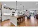 Open-concept kitchen with a large center island, pendant lighting, stainless appliances, and hardwood flooring at 2685 Scarecrow Way, Myrtle Beach, SC 29579