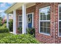 Close-up view of the brick front porch with a welcoming blue door and decorative wreath at 4536 Fringetree Dr., Murrells Inlet, SC 29576